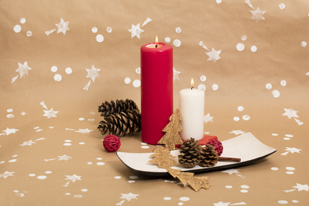 Christmas composition with candles, ornaments and pinecones, on handmade vintage background.の写真素材