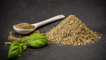 Aromatic spices basil. Spoon and pile of ground dried, fresh basil spice. Recipe ingredients
