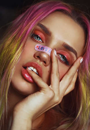 A girl with colored hair and a band aid on her nose