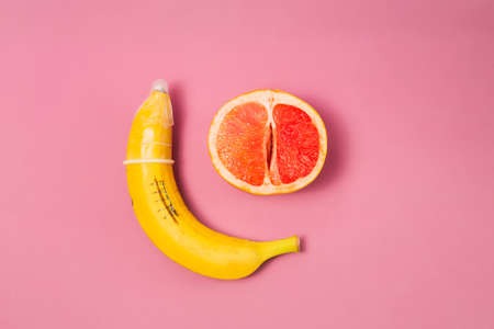 Sexy banana condom, grapefruit, concept.On a pink backgroundの写真素材