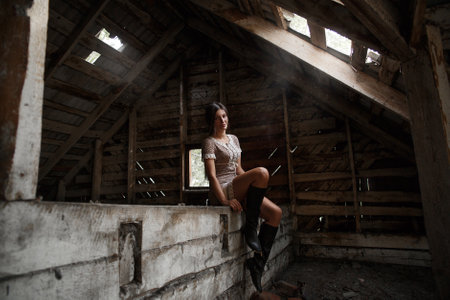 Portrait of a village girl in the attic, smoking a cigarette and blowing smokeの写真素材