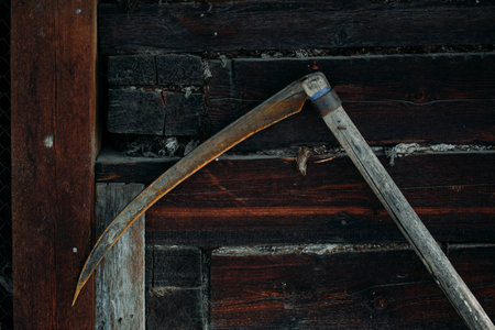 A rusty old metal braid hangs on a wooden wallの写真素材