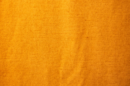 Golden yellow background from a textile material with pattern, closeup.の写真素材
