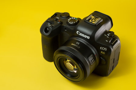 Canon r6 digital camera close-up, yellow background, glareのeditorial素材