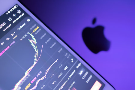 The Apple logo on the background of a stock exchange, share price, neon light.