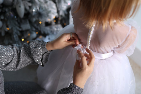 New Year, mom dresses her daughter. 2022の写真素材