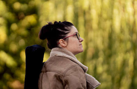 A beautifull young woman wondering in nature with blurry trees in the backgroundの写真素材