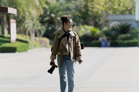A professional female photographer taking a photo sideways