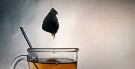 Tea bag dropping in a glass mugの写真素材