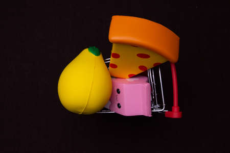 Toy plastic fruits and food isolated on black backgound. Toys for children's kitchenの写真素材