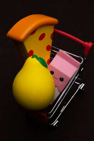 Toy plastic fruits and food isolated on black backgound. Toys for children's kitchen