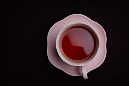 Ceramic Tea Cup on Black Background. Pink cup with black teaの写真素材