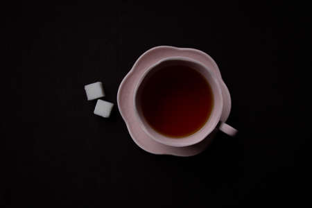 Ceramic Tea Cup on Black Background. Pink cup with black teaの写真素材