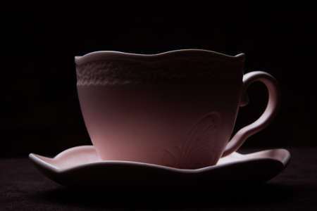 Ceramic Tea Cup on Black Background. Pink cup with black tea