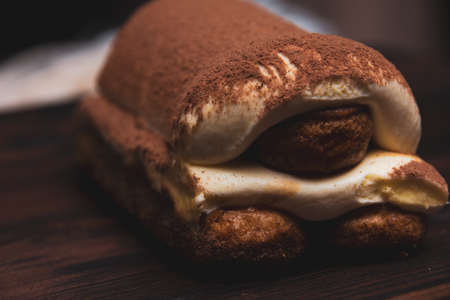 Photo of tiramisu cake close-up on a wooden backgroundの写真素材