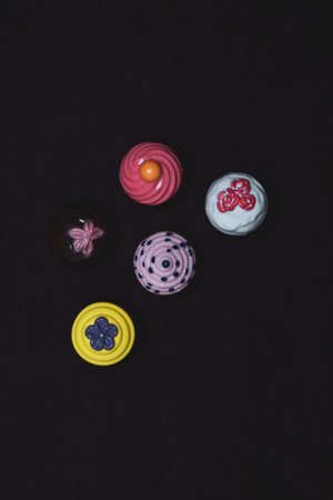 A set of toy cakes on a dark background. Plastic toy