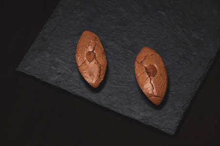 Two almond biscuits on a stone slab.の写真素材
