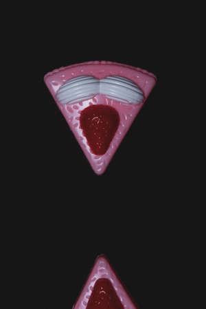 Toy piece of cake with stuffing on a dark background. Plastic toyの写真素材