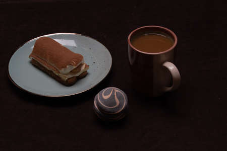 Morning breakfast of coffee and sweet marshmallows and tiramisu on dark background.の写真素材
