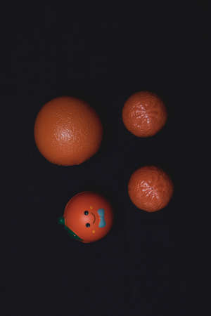 A set of toy oranges on a dark background.の写真素材