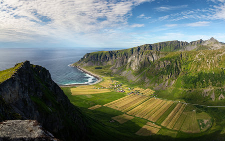 Hiker on the top of a cliff in Lofoten, Narvtinden mountain in spring time