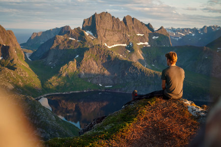 Hiker enjoying the view over Reinefjorden, Lofoten, Norwayの写真素材
