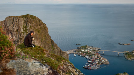 Hiker enjoying the view over Reinefjorden, Lofoten, Norway