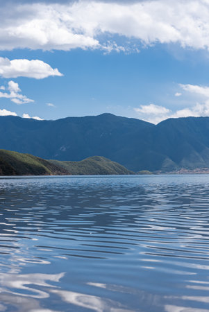 The beautiful scenery of Lugu Lake in China under the blue sky and white cloudsの写真素材