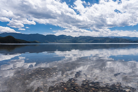 The beautiful scenery of Lugu Lake in China under the blue sky and white cloudsの写真素材