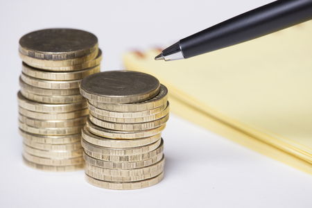 coins, notebook and penの写真素材