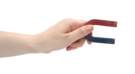 Magnet in a female hand on a white background.の写真素材