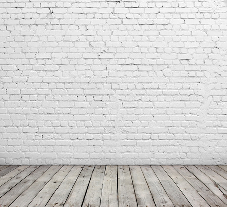 Old white brick wall and wood floor.