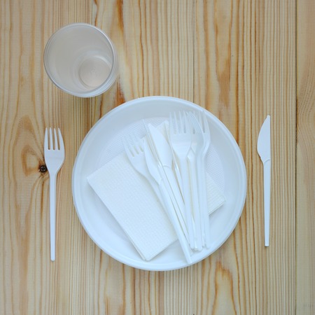 Disposable plastic plate on a wooden background.の写真素材