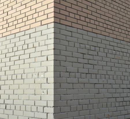 House corner, brick wall painted with white paint.