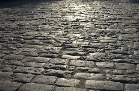 Abstract background. Old cobblestone pavement close-up.の写真素材
