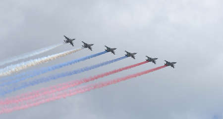 Six Russian military aircraft fly in the sky. Fighters in the sky over Moscow smoke show the flag of...