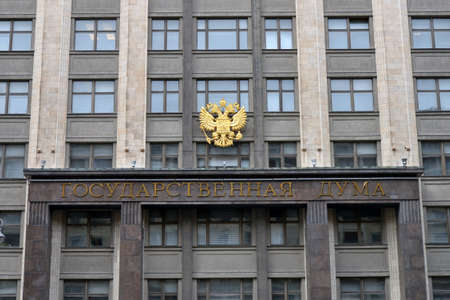 Moscow, Russia - May 4, 2021: Golden coat of arms of Russia on the building of the State Duma. Building of The State Duma of Russian Federation in Moscow, Russia.のeditorial素材