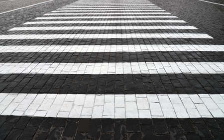Abstract background. Old cobblestone pavement closeup and white line.