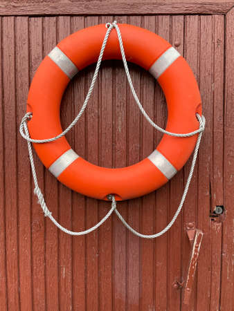 The red lifebuoy is hung on the wall.の写真素材