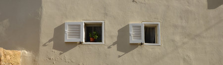 Two Small windows on the wall of the house