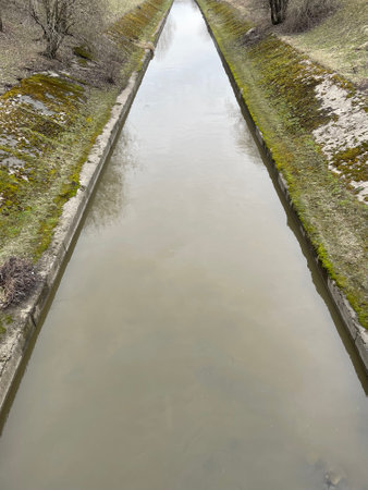 Old water channel with flowing water. River with concrete banks in the cityの写真素材