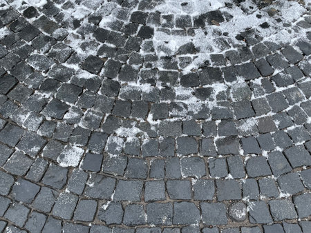 White Snow lies on an old cobblestone pavementの写真素材