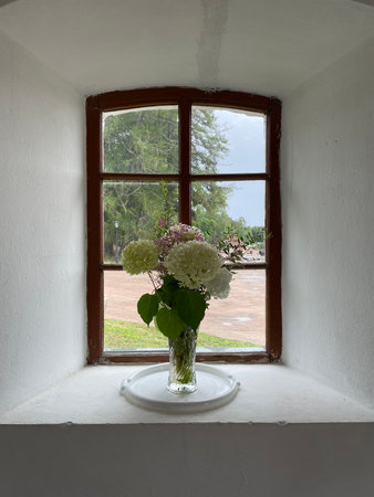 Brown window and white flowers in a glass vase