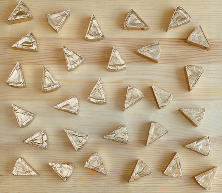 triangles of processed cheese on a wooden table in a variety of formsの写真素材