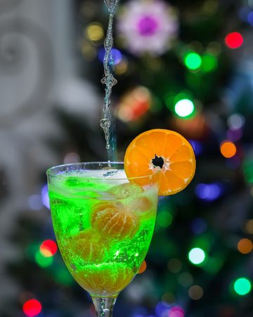 Pours champagne in a glass with ice and tangerines .の写真素材