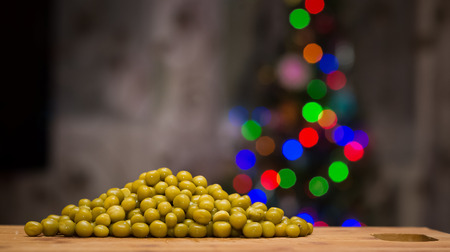 Peas on a cutting board. In the background - Christmas tree. The process of preparing the salad.の写真素材