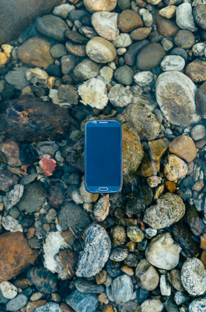 Lost man modern smartphone supported floating on the water.の写真素材