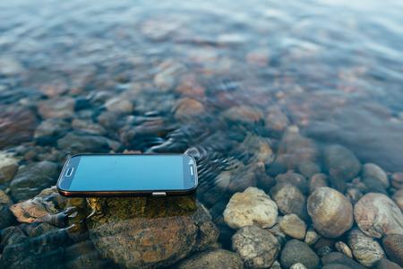 Lost man modern smartphone supported floating on the water.の写真素材