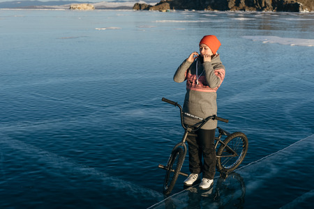Girl standing on a bmx on the beautiful and dangerous ice.の写真素材