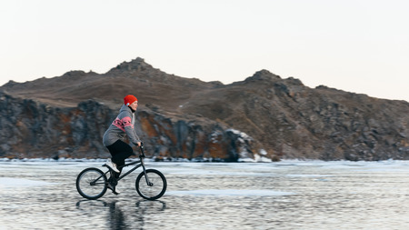 The girl goes on a bmx on the beautiful and dangerous ice.の写真素材